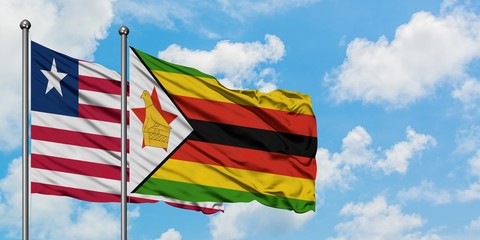 Liberia and Zimbabwe flag waving in the wind against white cloudy blue sky together. Diplomacy concept, international relations.