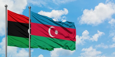 Libya and Azerbaijan flag waving in the wind against white cloudy blue sky together. Diplomacy concept, international relations.