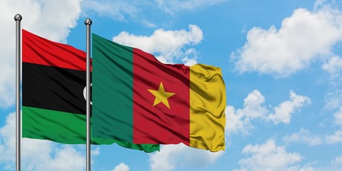 Libya and Cameroon flag waving in the wind against white cloudy blue sky together. Diplomacy concept, international relations.