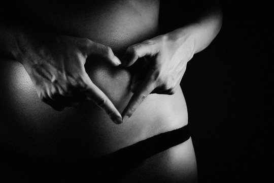 Picture of pregnant woman touching her belly with hands