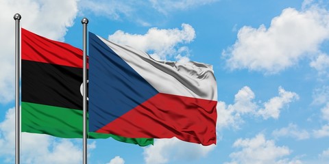 Libya and Czech Republic flag waving in the wind against white cloudy blue sky together. Diplomacy...