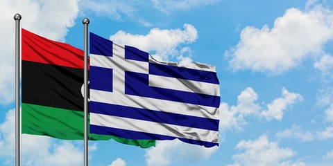 Libya and Greece flag waving in the wind against white cloudy blue sky together. Diplomacy concept, international relations.