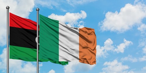 Libya and Ireland flag waving in the wind against white cloudy blue sky together. Diplomacy concept, international relations.