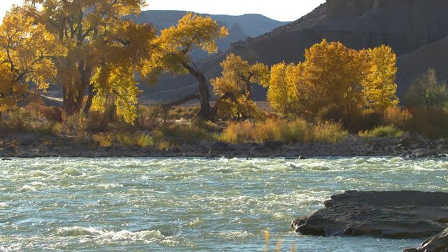 Slow motion of the Green River flowing in Fall desert landscape in Utah at Swasey's Beach.