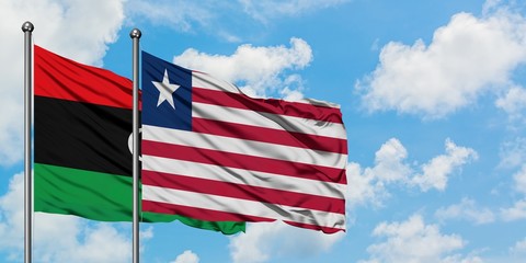 Libya and Liberia flag waving in the wind against white cloudy blue sky together. Diplomacy concept, international relations.