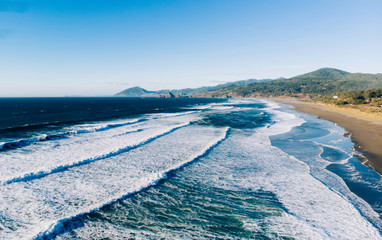 Aerial breathtaking view of wonderful nature landscape, Bird's eye view seashore with big foamy waves with turquoise water in coastal environment. Pacific ocean power, sandy beach of California