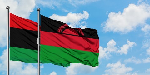 Libya and Malawi flag waving in the wind against white cloudy blue sky together. Diplomacy concept, international relations.