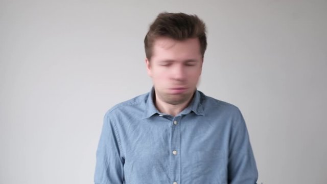 Young crazy man hitting himself in face punishing himself with hands.