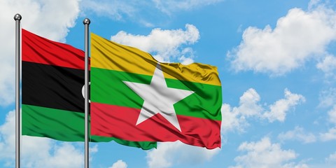 Libya and Myanmar flag waving in the wind against white cloudy blue sky together. Diplomacy concept, international relations.