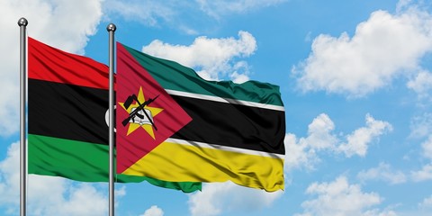 Libya and Mozambique flag waving in the wind against white cloudy blue sky together. Diplomacy concept, international relations.
