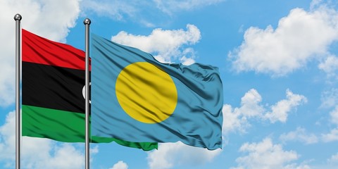 Libya and Palau flag waving in the wind against white cloudy blue sky together. Diplomacy concept, international relations.