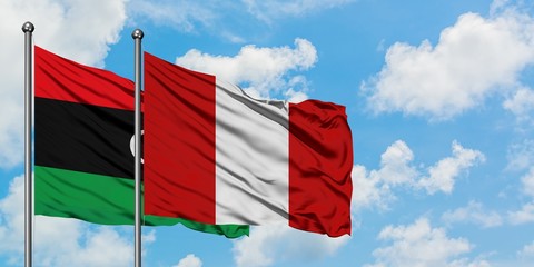 Libya and Peru flag waving in the wind against white cloudy blue sky together. Diplomacy concept, international relations.