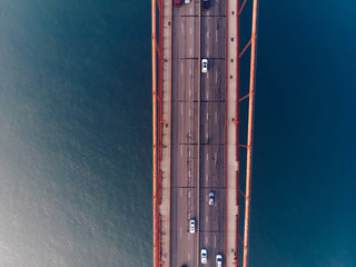 Aerial view of Golden Gate Bridge in foggy visibility during evening time, metropolitan transportation  infrastructure, birds eye view of automotive car vehicles on road of suspension construction © BullRun