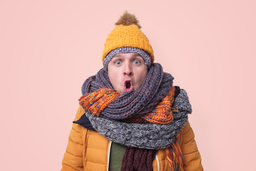 Handsome caucasian funny man in several hats and scarfs.