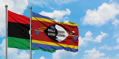 Libya and Swaziland flag waving in the wind against white cloudy blue sky together. Diplomacy concept, international relations.