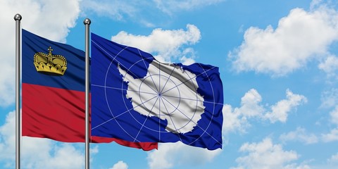 Liechtenstein and Antarctica flag waving in the wind against white cloudy blue sky together. Diplomacy concept, international relations.
