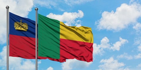 Liechtenstein and Benin flag waving in the wind against white cloudy blue sky together. Diplomacy...