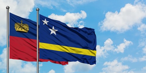Liechtenstein and Curacao flag waving in the wind against white cloudy blue sky together. Diplomacy concept, international relations.