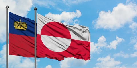 Liechtenstein and Greenland flag waving in the wind against white cloudy blue sky together. Diplomacy concept, international relations.