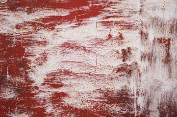 Abstract background. Faded from time and weather painted white on a red primer metal surface with cracks, stains and rust. Background, structure.