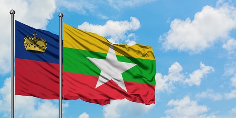 Liechtenstein and Myanmar flag waving in the wind against white cloudy blue sky together. Diplomacy...