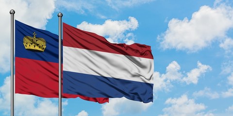 Liechtenstein and Netherlands flag waving in the wind against white cloudy blue sky together. Diplomacy concept, international relations.