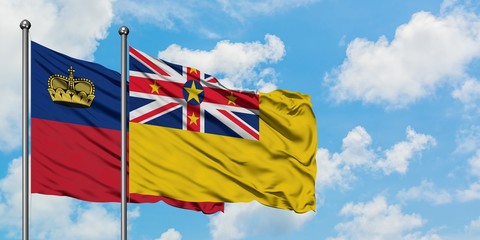 Liechtenstein and Niue flag waving in the wind against white cloudy blue sky together. Diplomacy concept, international relations.