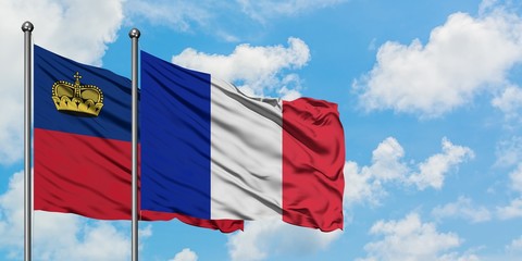 Liechtenstein and Reunion flag waving in the wind against white cloudy blue sky together. Diplomacy concept, international relations.