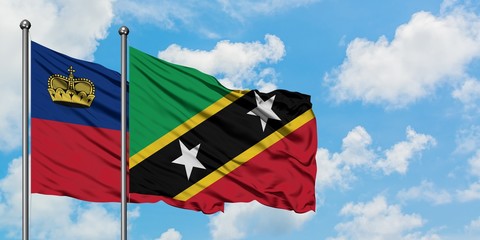 Liechtenstein and Saint Kitts And Nevis flag waving in the wind against white cloudy blue sky together. Diplomacy concept, international relations.