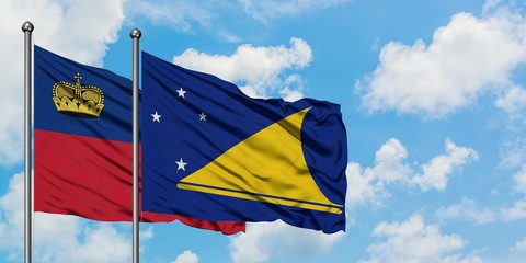 Liechtenstein and Tokelau flag waving in the wind against white cloudy blue sky together. Diplomacy concept, international relations.