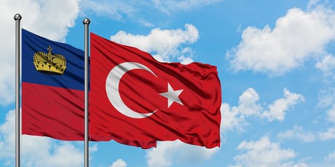 Liechtenstein and Turkey flag waving in the wind against white cloudy blue sky together. Diplomacy...
