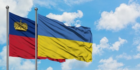 Liechtenstein and Ukraine flag waving in the wind against white cloudy blue sky together. Diplomacy concept, international relations.