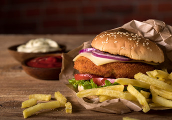 Fresh burger on wooden table and brick wall background