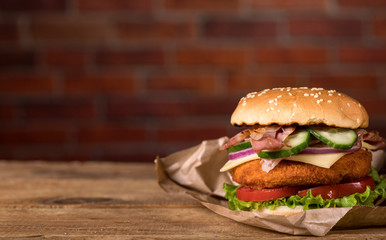 Fresh burger on wooden table and brick wall background