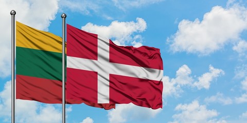Lithuania and Denmark flag waving in the wind against white cloudy blue sky together. Diplomacy concept, international relations.