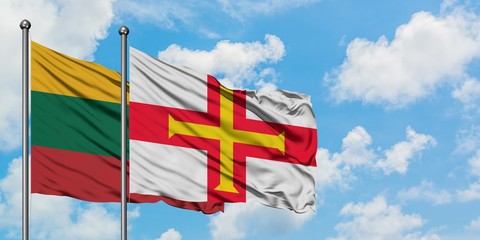 Lithuania and Guernsey flag waving in the wind against white cloudy blue sky together. Diplomacy concept, international relations.