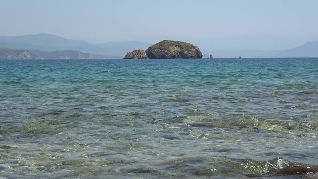 Flat island, Fethiye area, Turkey - 25th of July 2019: 4K Zoom out an uninhabited island and landswell
