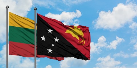 Lithuania and Papua New Guinea flag waving in the wind against white cloudy blue sky together. Diplomacy concept, international relations.
