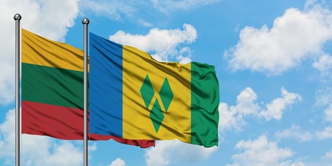 Lithuania and Saint Vincent And The Grenadines flag waving in the wind against white cloudy blue...