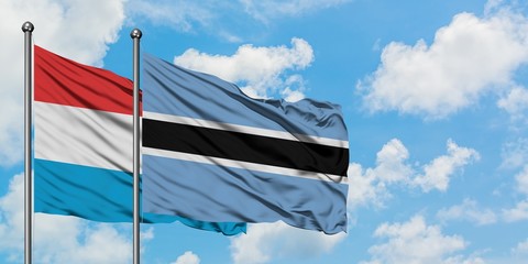 Luxembourg and Botswana flag waving in the wind against white cloudy blue sky together. Diplomacy concept, international relations.