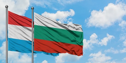 Luxembourg and Bulgaria flag waving in the wind against white cloudy blue sky together. Diplomacy concept, international relations.