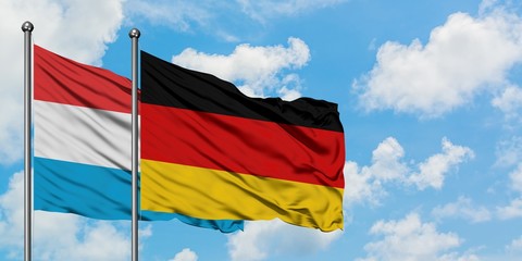 Luxembourg and Germany flag waving in the wind against white cloudy blue sky together. Diplomacy concept, international relations.