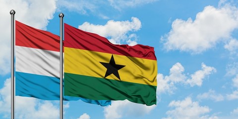 Luxembourg and Ghana flag waving in the wind against white cloudy blue sky together. Diplomacy concept, international relations.