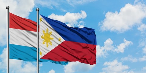Luxembourg and Philippines flag waving in the wind against white cloudy blue sky together. Diplomacy concept, international relations.