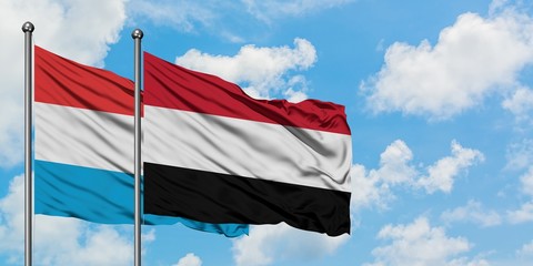 Luxembourg and Yemen flag waving in the wind against white cloudy blue sky together. Diplomacy concept, international relations.