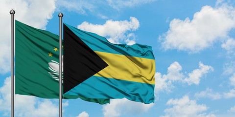 Macao and Bahamas flag waving in the wind against white cloudy blue sky together. Diplomacy concept, international relations.
