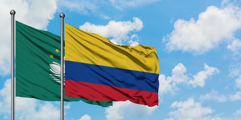 Macao and Colombia flag waving in the wind against white cloudy blue sky together. Diplomacy concept, international relations.