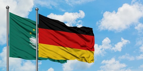 Macao and Germany flag waving in the wind against white cloudy blue sky together. Diplomacy concept, international relations.