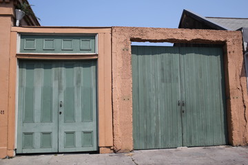 closed old green wooden doors and shutters in orange exterior wall