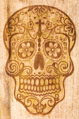 Fototapeta na wymiar Art design skull head smiley face day of the dead festival. Engraving on hardwood with gold paint. Halloween display.